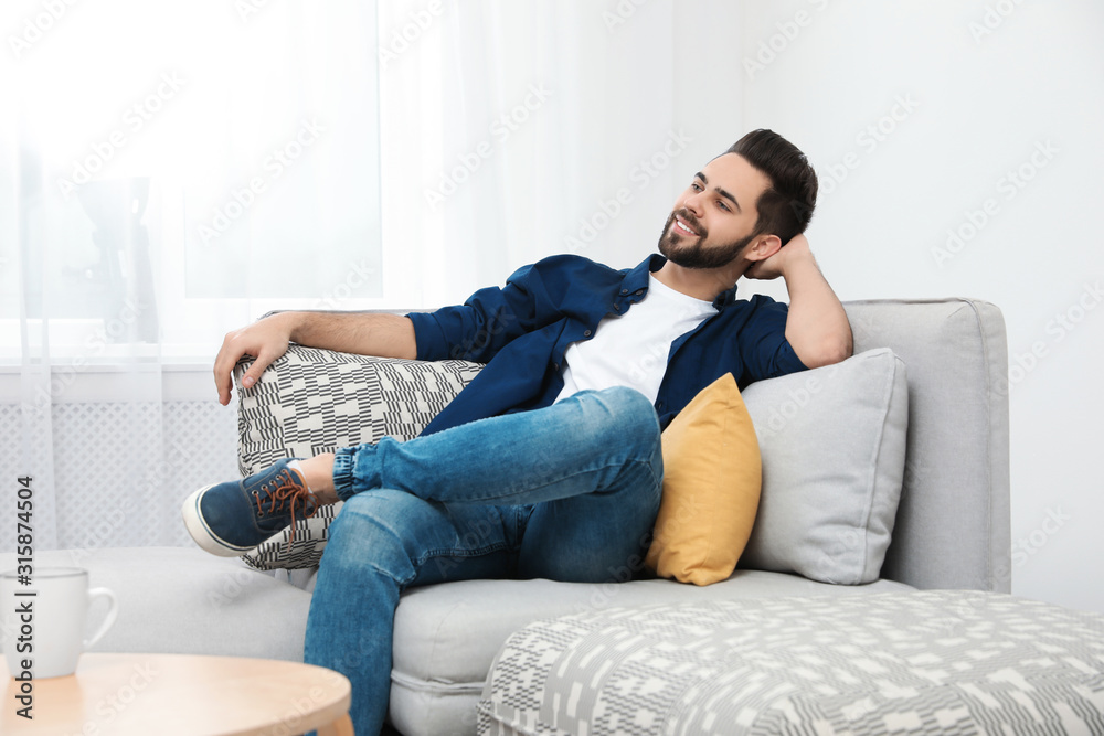 Young man relaxing on couch at home