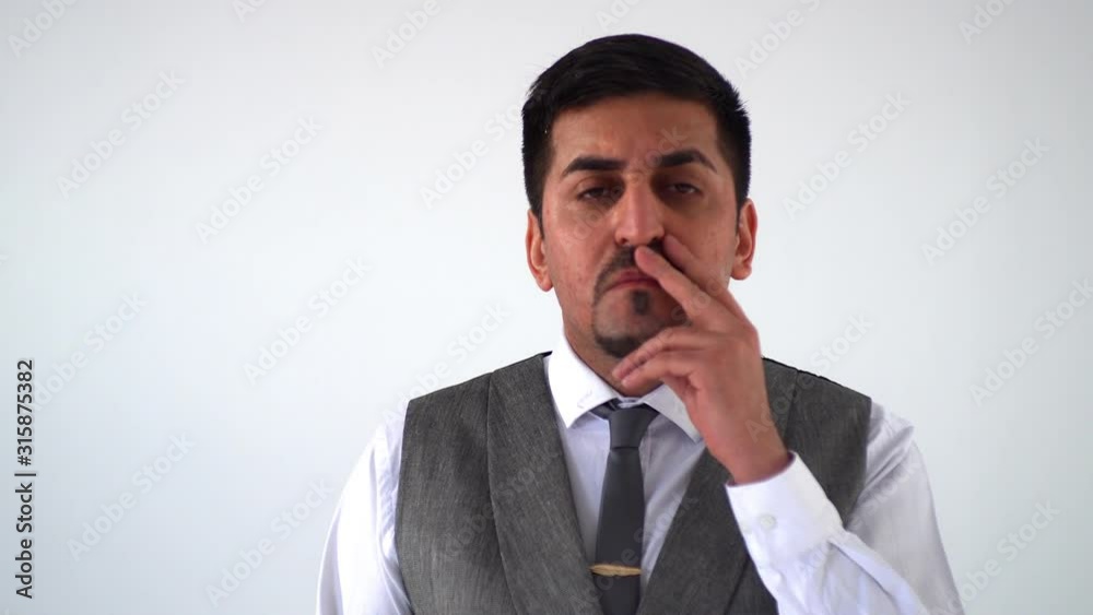 the thoughtful man scratches his temple and beard, remembers and points to the camera and nods approvingly. Focused Arab businessman the thoughtful man scratches his temple and beard, remembers and points to the camera and nods approvingly. Focused Arab businessman