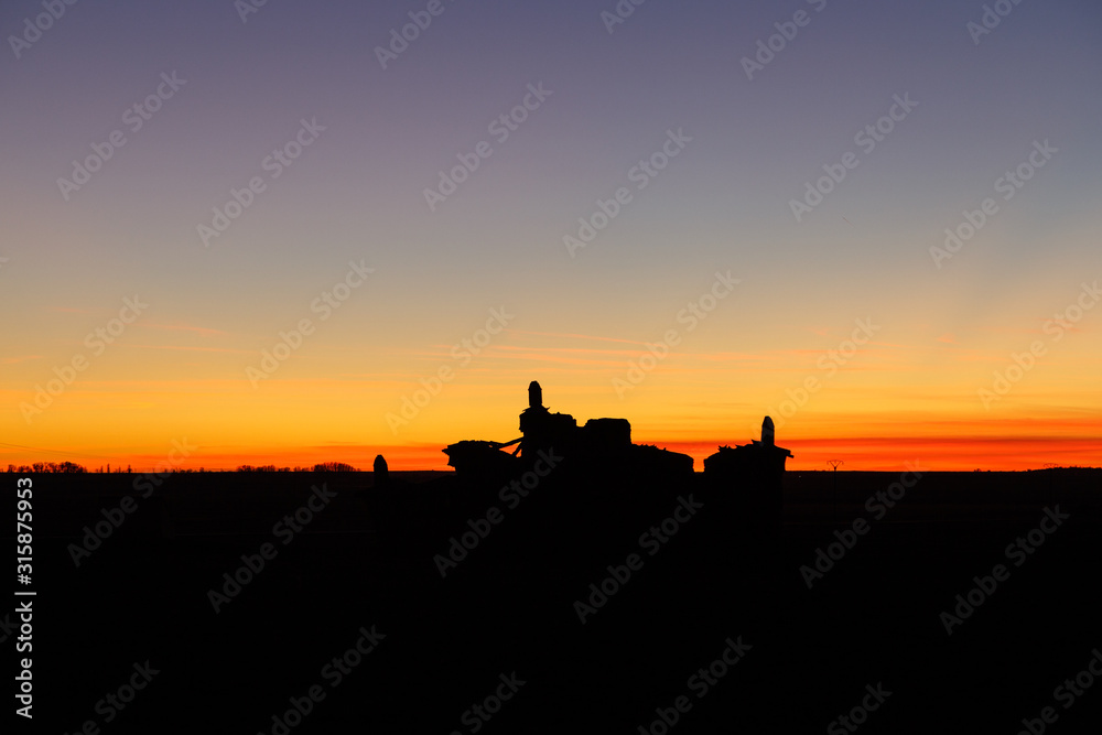 Fototapeta premium Paisaje a contraluz de los restos de antiguo palomar al atardecer. Otero de Sariegos. Reserva Natural de Lagunas de Villafáfila, Zamora, España.