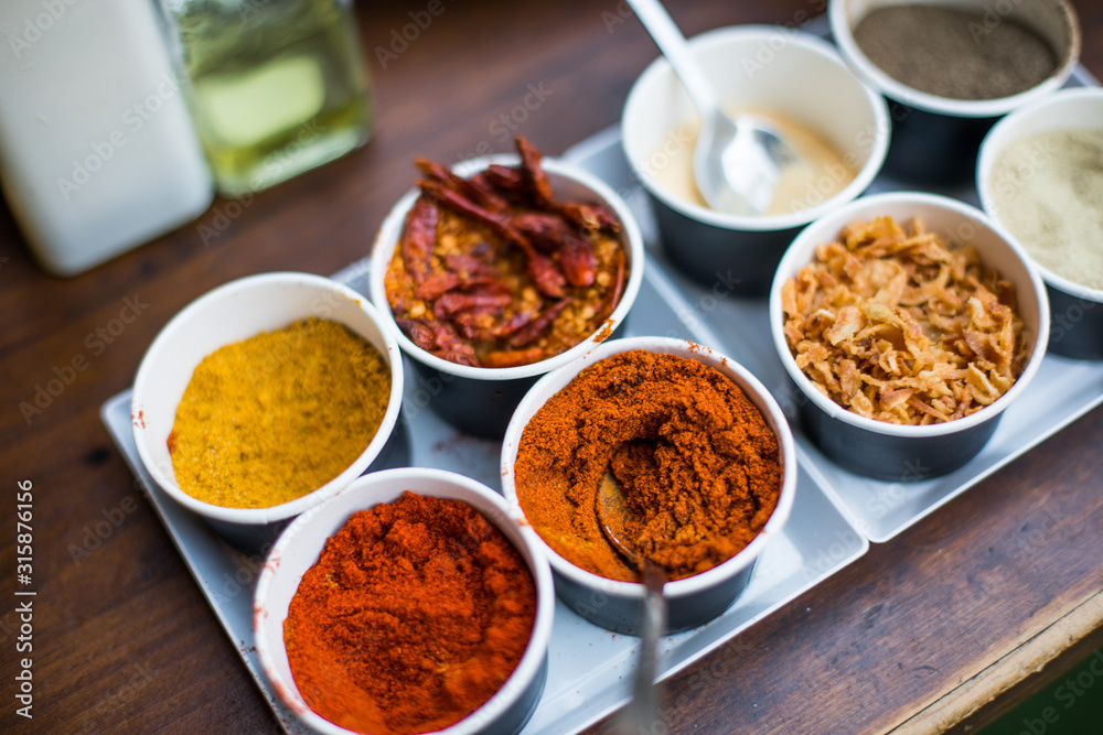 Various colored spices in recipients