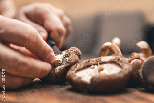 Cleaning and cutting shiitake mushrooms for a delicious meal, closeup photo