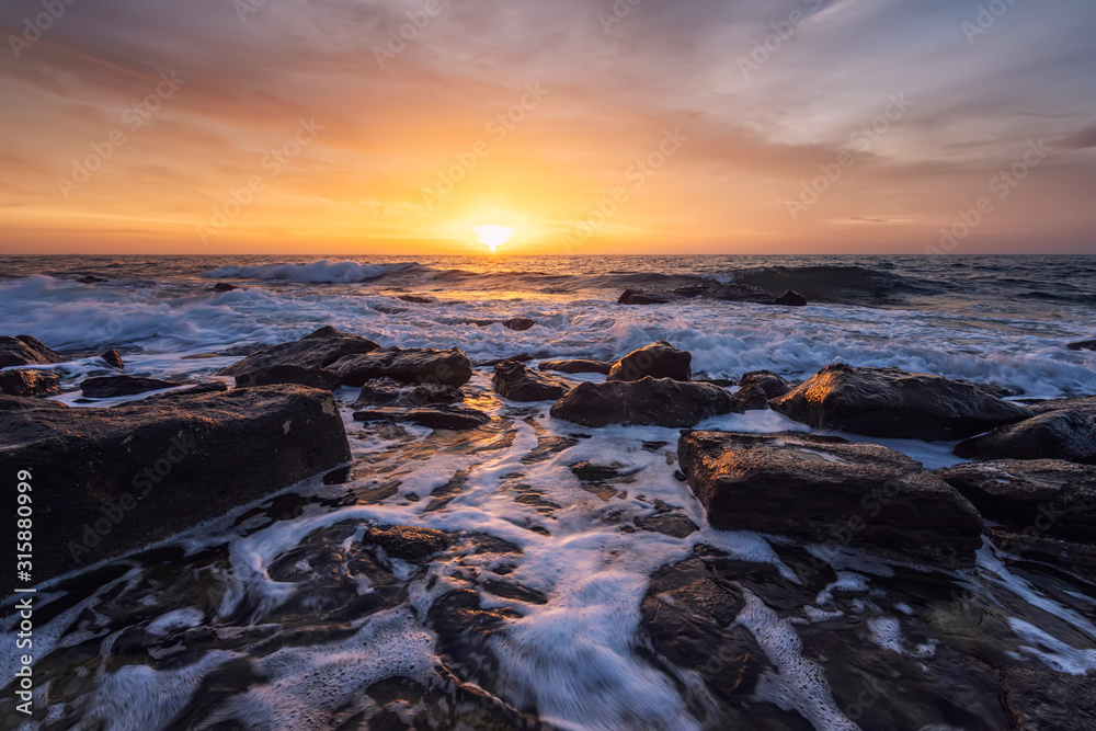 The stunning seascape with the colorful sky and water foam at the rocky coastline of the Black Sea The stunning seascape with the colorful sky and water foam at the rocky coastline of the Black Sea