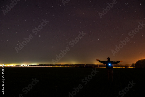 silhouette of a man on a background of field and starry sky © Dva4e_410