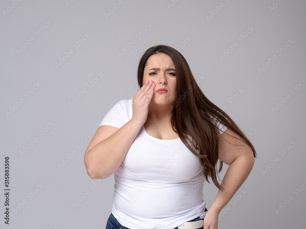 Plus Size Model with a hand holding a sore tooth Plus Size Model with a hand holding a sore tooth