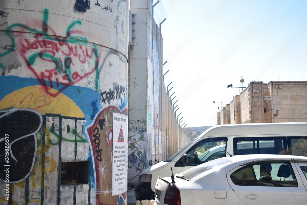Cars parked in front of the Separation Wall in Bethlehem