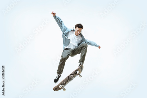 Fényképezés Caucasian young skateboarder riding isolated on a white studio background