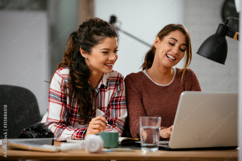 Two friends working together. Colleagues discussing work 