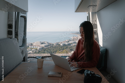 Woman sitting in vehicle looking at view while working