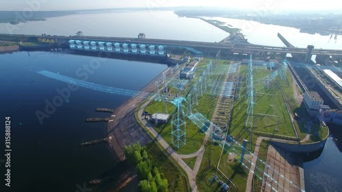 Overall aerial orbit view a high voltage electric power tower, hydroelectric power station and electric substation with infographic power flows motion graphics. Tall pylons and hog voltage cables.