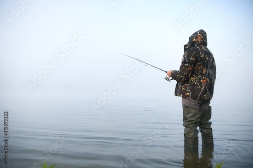 fisherman on the river in fog with copy space