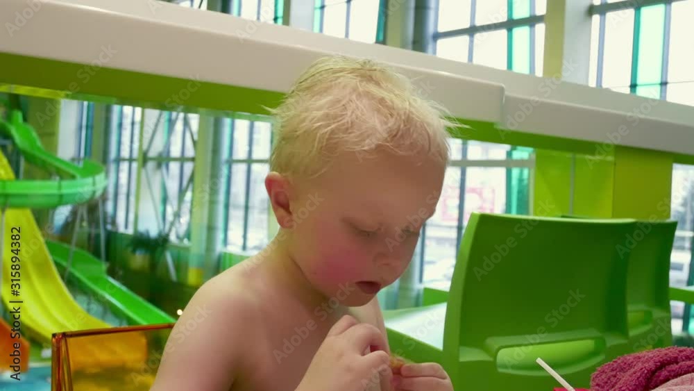 The kid eats French fries.A little boy with blond hair eats fast food. The kid eats French fries.A little boy with blond hair eats fast food.