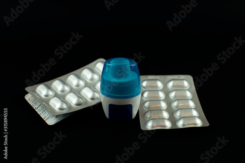 Capsule inhaler with a set of capsules on a black background. photo