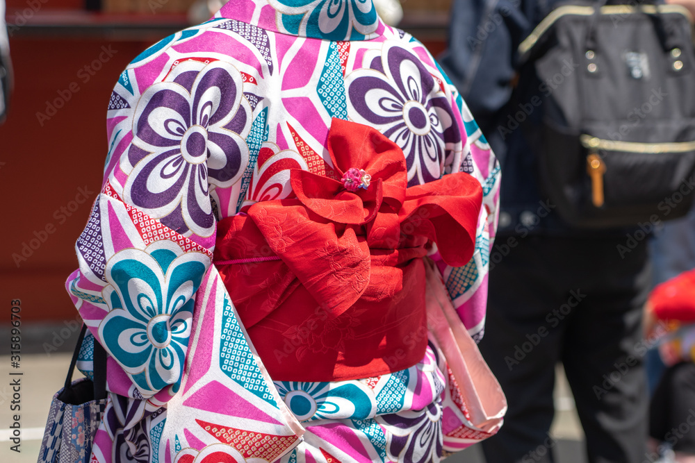 Young girl wearing Japanese kimono standing in front of Sensoji Temple