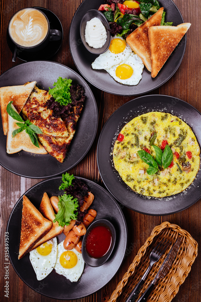 Traditional breakfast with fried eggs, sausages, beans, mushrooms, grilled tomatoes and bacon on wooden background. Top view Traditional breakfast with fried eggs, sausages, beans, mushrooms, grilled tomatoes and bacon on wooden background. Top view