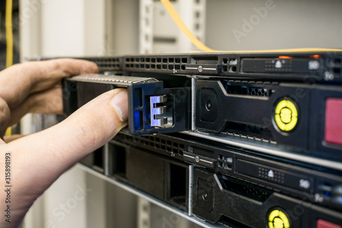 Replacing a hard drive in computer hardware. Modular repair of database server hardware. Technical work in the server room of the data center is a close-up. © Климов Максим