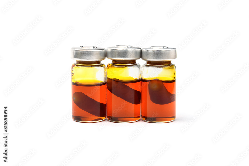 Glass medical ampule with the capsule and the oil inside isolated on white background. Glass medical ampule with the capsule and the oil inside isolated on white background.