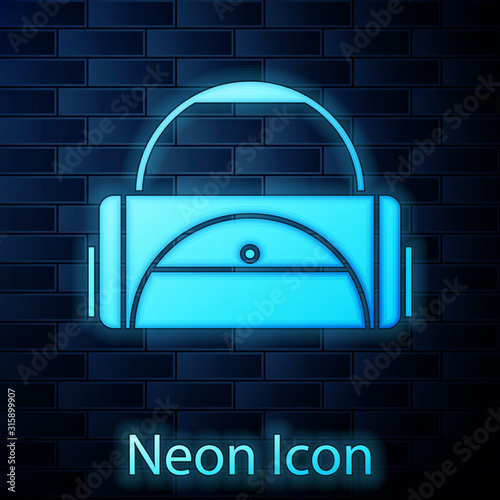 Glowing neon Sport bag icon isolated on brick wall background. Vector Illustration