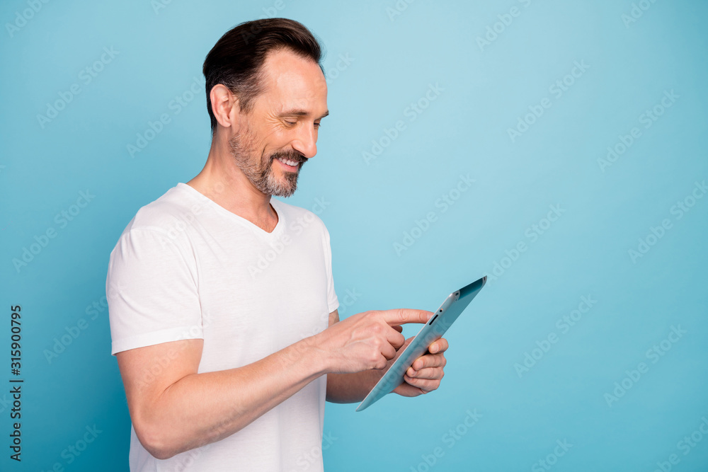 Close-up profile side view portrait of nice attractive cheerful cheery guy using digital device chatting browsing app isolated on bright vivid shine vibrant teal green blue turquoise color background Close-up profile side view portrait of nice attractive cheerful cheery guy using digital device chatting browsing app isolated on bright vivid shine vibrant teal green blue turquoise color background