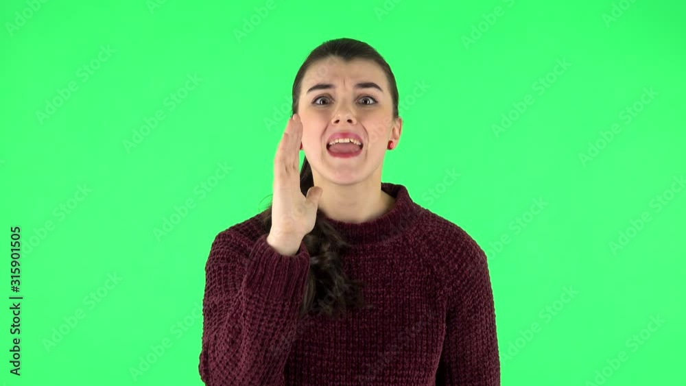 Annoyed girl screams calling someone on a green screen at studio. Green screen Annoyed girl screams calling someone on a green screen at studio. Green screen