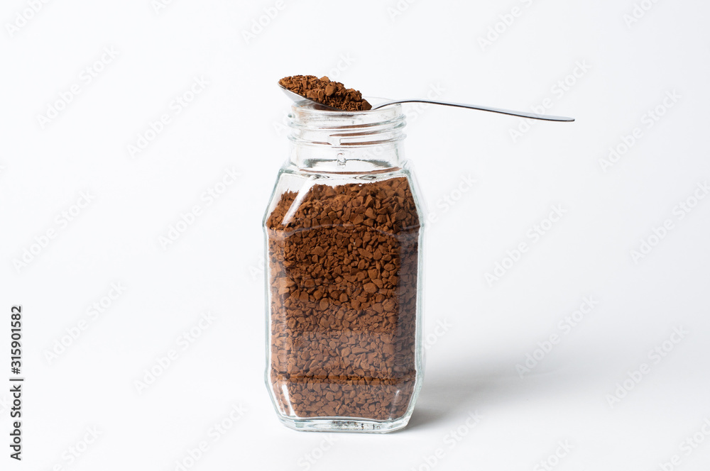 Instant coffee in jar and spoon on a white background Instant coffee in jar and spoon on a white background