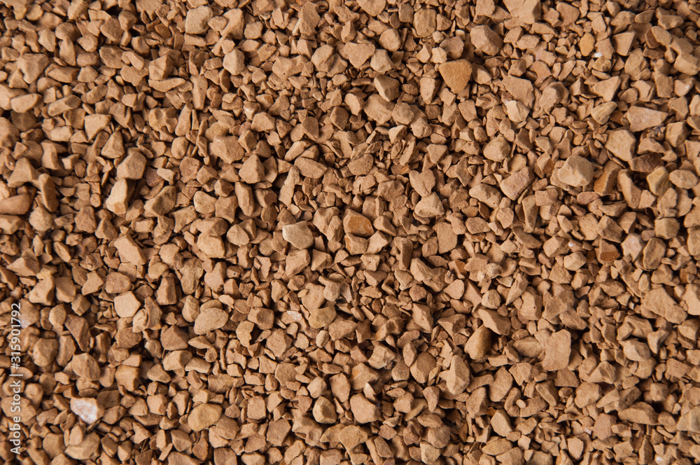Instant coffee granules close-up, brown background with place for text Instant coffee granules close-up, brown background with place for text