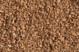 Instant coffee granules close-up, brown background with place for text