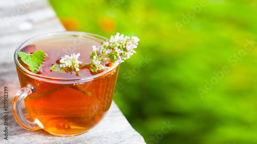 Fresh tasty hot tea with melissa outdoor in summer. Medicine healthy