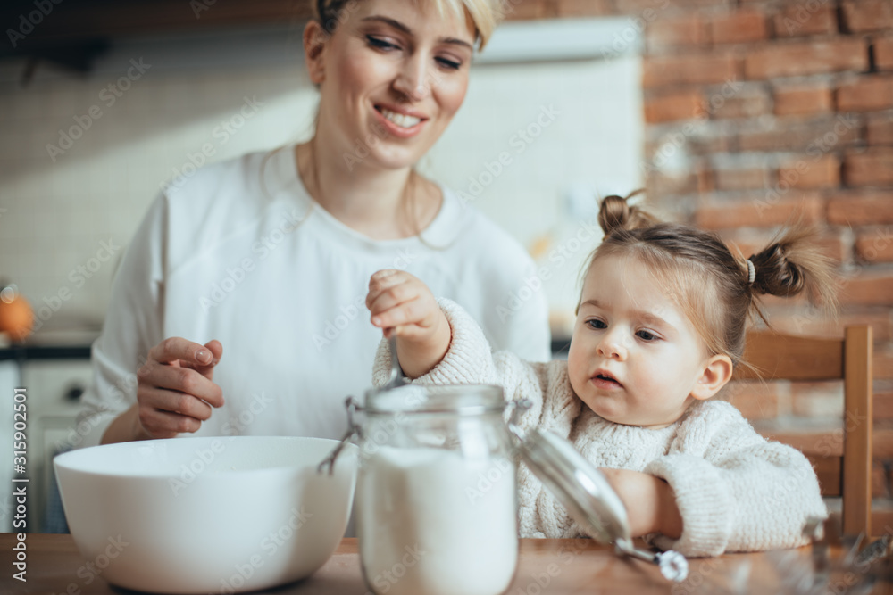 Mother and daughter baking cookies in their kitchen Mother and daughter baking cookies in their kitchen