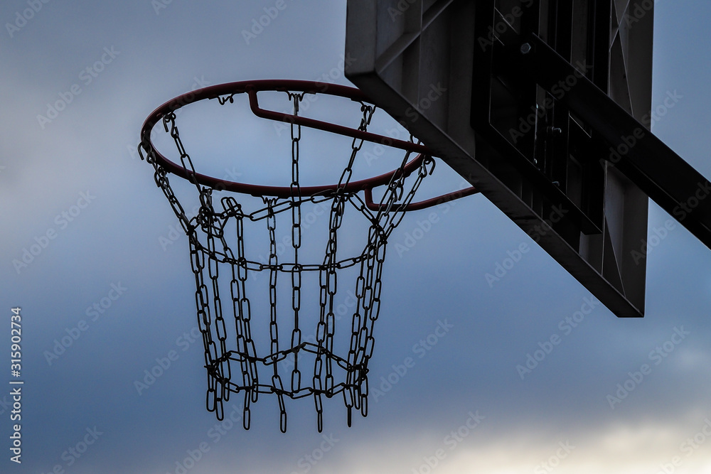 Streetball basketball basket with chains in the place of net, on a dark day