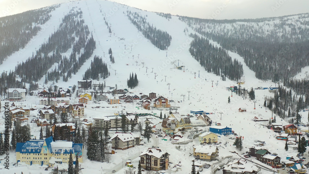 Mounting skiing resort. People skiing and snowboarding from the mountain.Beautiful view from above