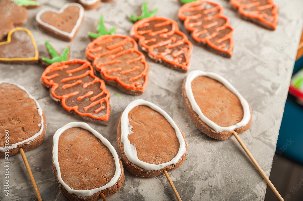 The process of painting gingerbread with glaze. Flat lay cookie eggs. Handpainted gingerbread bunnies and eggs for Easter and copy space. The process of painting gingerbread with glaze. Flat lay cookie eggs. Handpainted gingerbread bunnies and eggs for Easter and copy space.