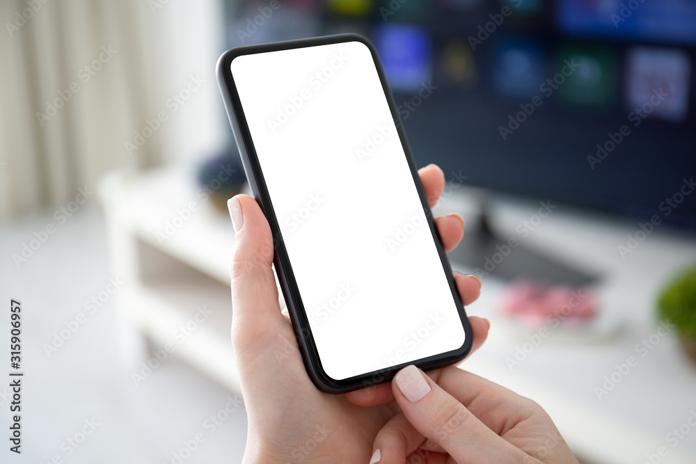 female hands holding phone with isolated screen background of TV