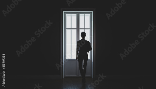 A woman's silhouette in front of the window. Black and white. Concept of loneliness. 3d illustration