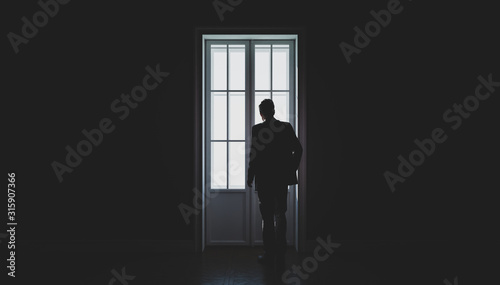 A man's silhouette in front of the window. Black and white. Concept of loneliness. 3d illustration