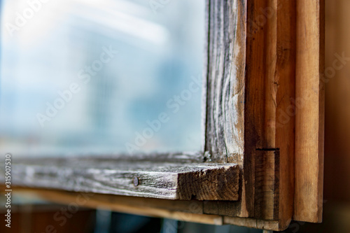 Close up view on part of old wooden window's frame construction with reflection on glass. Copy space, selective focus.