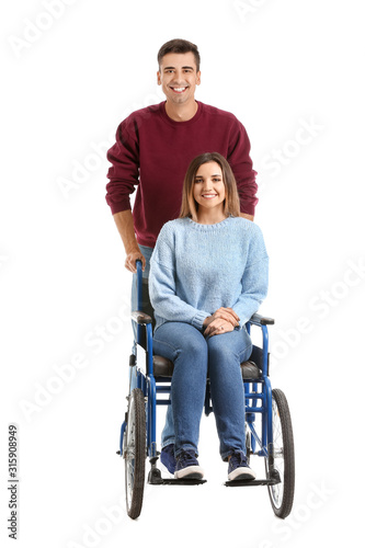 Handicapped young woman in wheelchair and her husband on white background