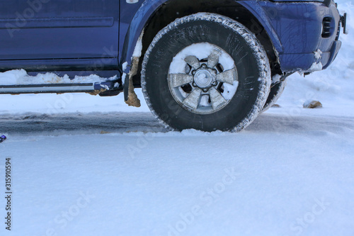 Car wheel on white snow. Close-up.