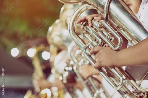 Принти на полотні Male student with friends blow the euphonium with the band for performance on stage at night