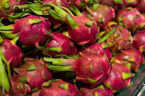 Dragon fruit with a lots of dragon fruit on a background. Dragon fruit or pitaya. Tropical and exotic fruits. Healthy and vitamin food concept.