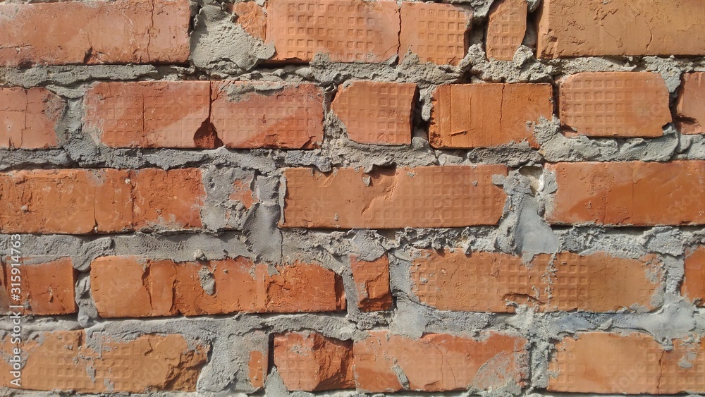 Obraz premium Brick background. Sloppy masonry of bricks of orange shades. For inscriptions and elements.