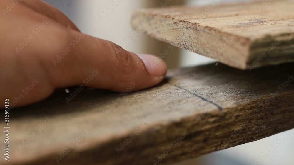 Close up hand of woodworker touching a wood piece to respect and feel precious to material. Close up hand of woodworker touching a wood piece to respect and feel precious to material.