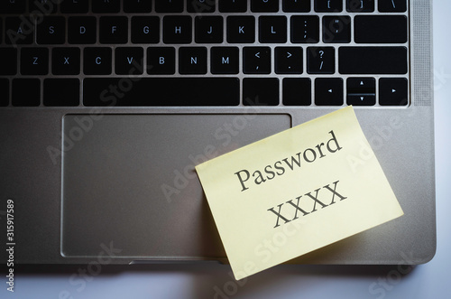 Internet security concept, yellow note paper attach on laptop pad with word "password XXXX"