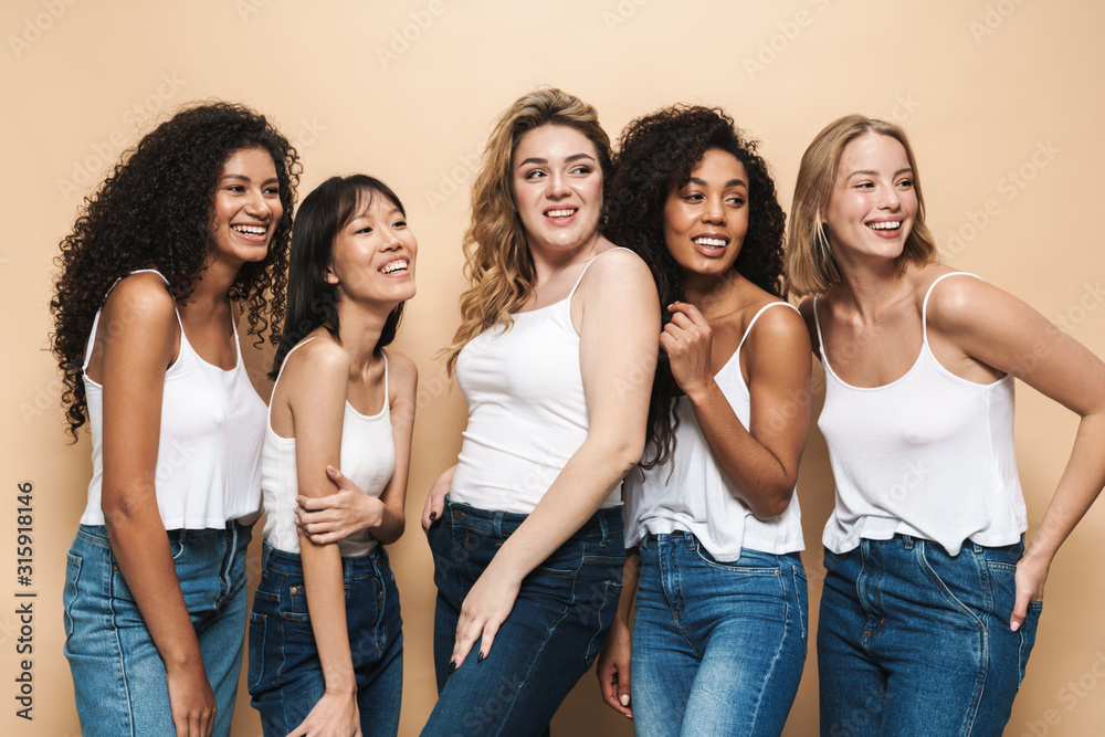 Image of beautiful multinational women smiling and looking aside Image of beautiful multinational women smiling and looking aside