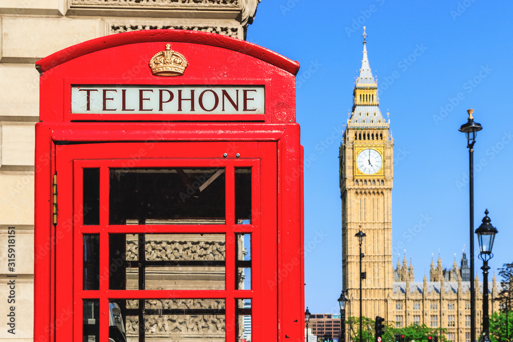 Obraz premium Red telephone box with Big Ben against blue sky in the background
