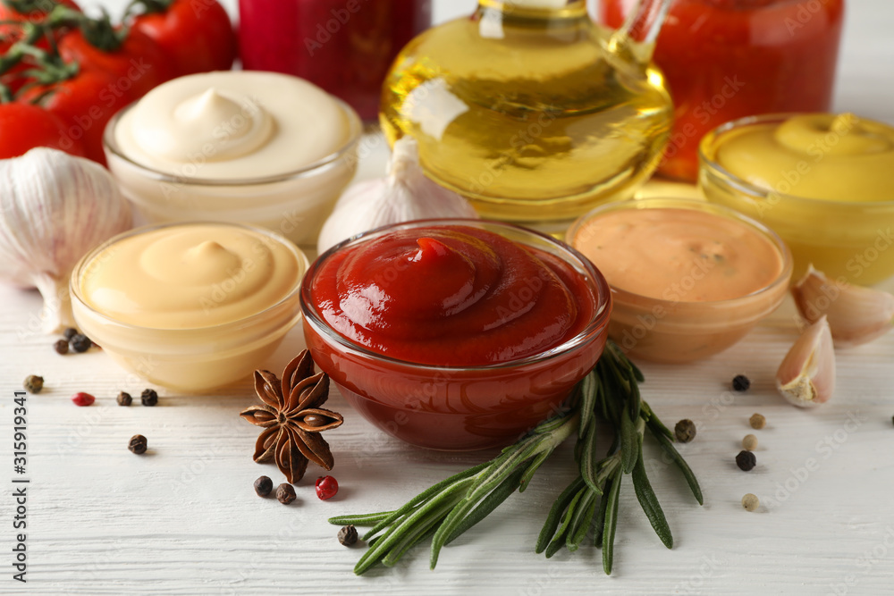 Set of different delicious sauces, garlic, cherry tomatoes, olive oil on white background, closeup. Space for text Set of different delicious sauces, garlic, cherry tomatoes, olive oil on white background, closeup. Space for text