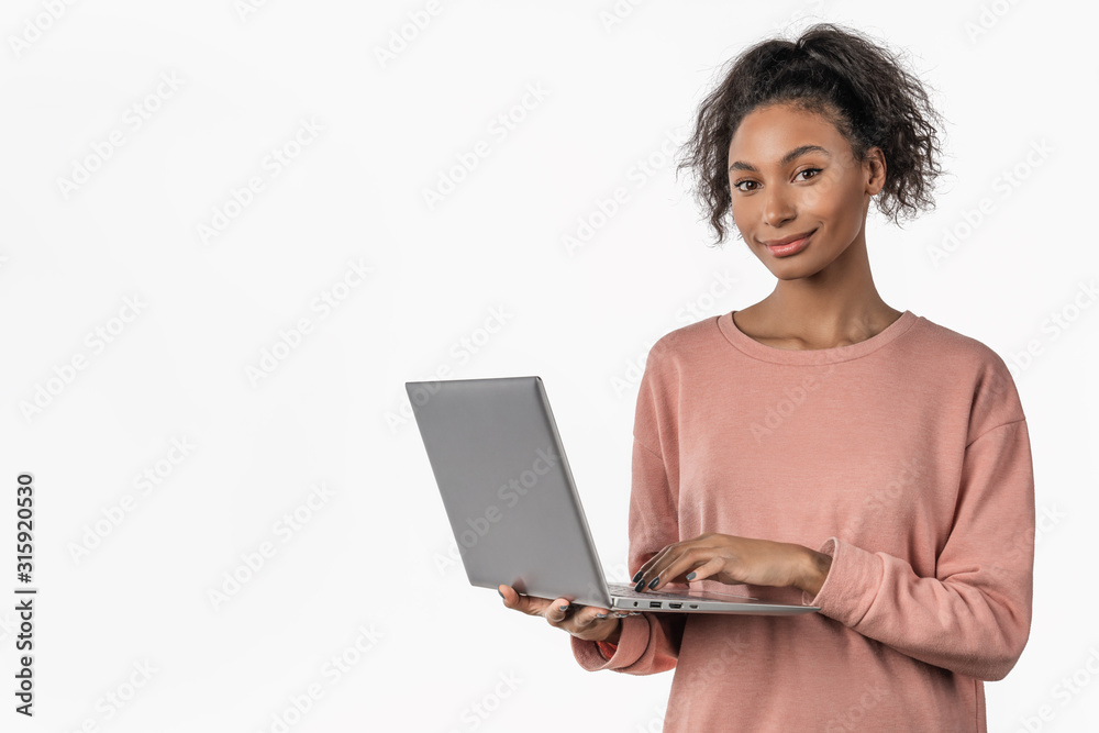 Happy young african girl using laptop computer isolated over white background Happy young african girl using laptop computer isolated over white background