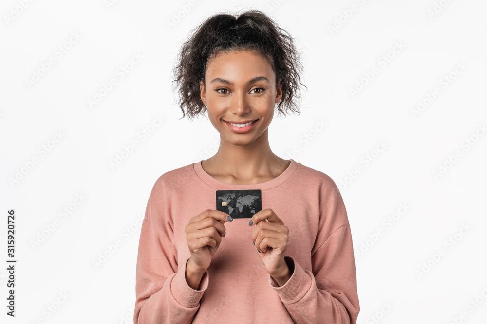 Beautiful young african excited emotional happy woman posing isolated over white background holding credit card Beautiful young african excited emotional happy woman posing isolated over white background holding credit card
