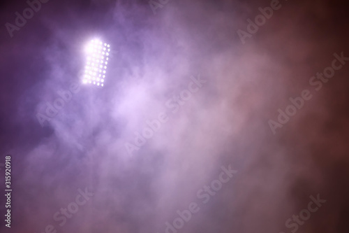 stadium lights and smoke against dark night sky background