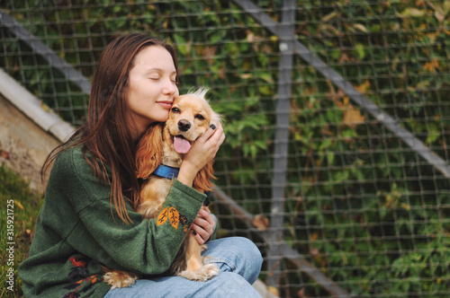 woman with american cocker spaniel walks at autumn park