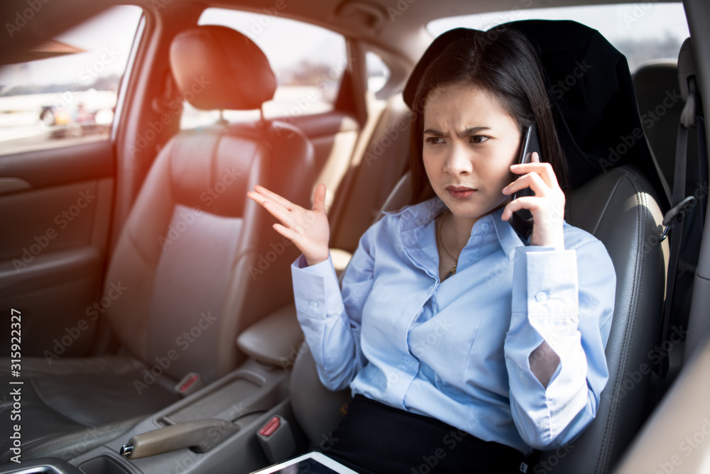Work stress,Exhausted, Tired,Asian woman talk by mobile calling on cellular phone while sitting in her car, driving under the influence,driver is safely talking by smartphone in a car concept Work stress,Exhausted, Tired,Asian woman talk by mobile calling on cellular phone while sitting in her car, driving under the influence,driver is safely talking by smartphone in a car concept